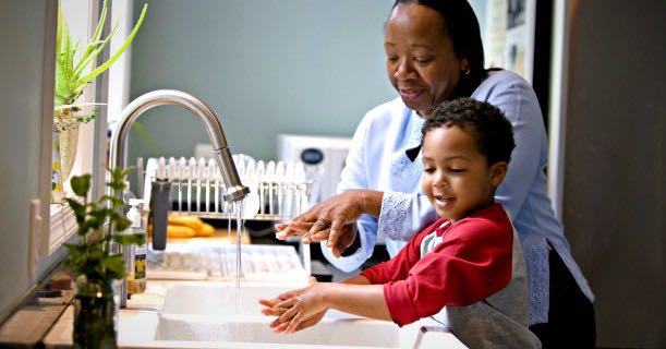 mom-and-kid-washing-hands-in-kitchen-image